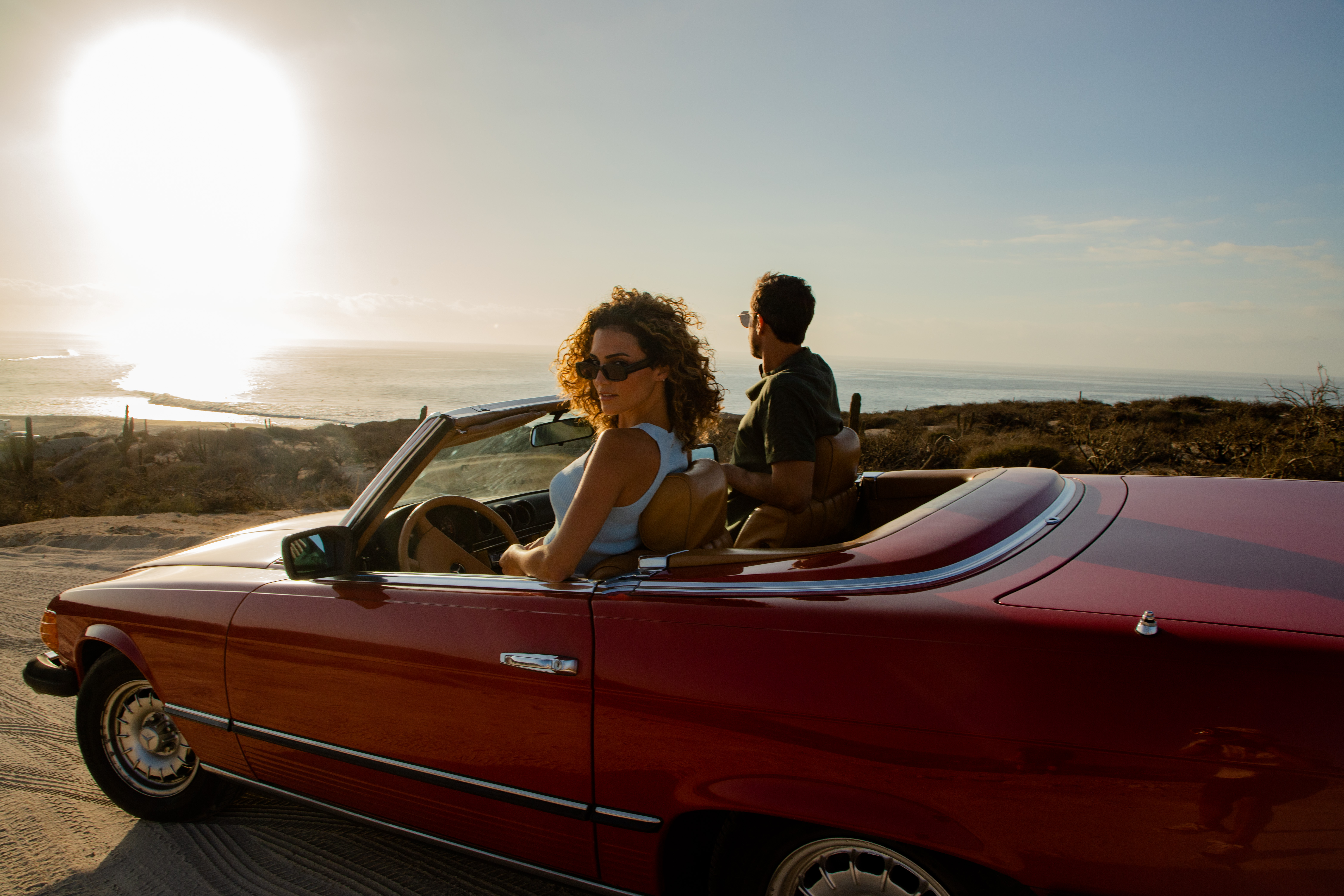 a man and woman in a convertible car