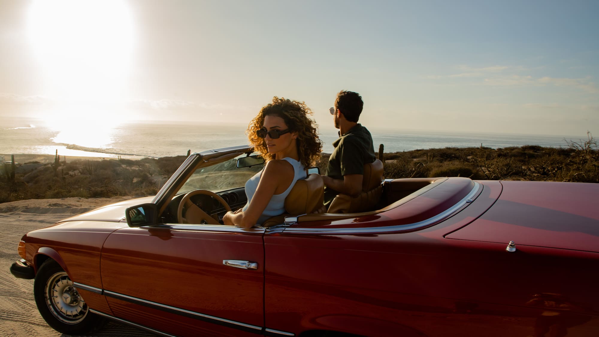 a man and woman in a convertible car