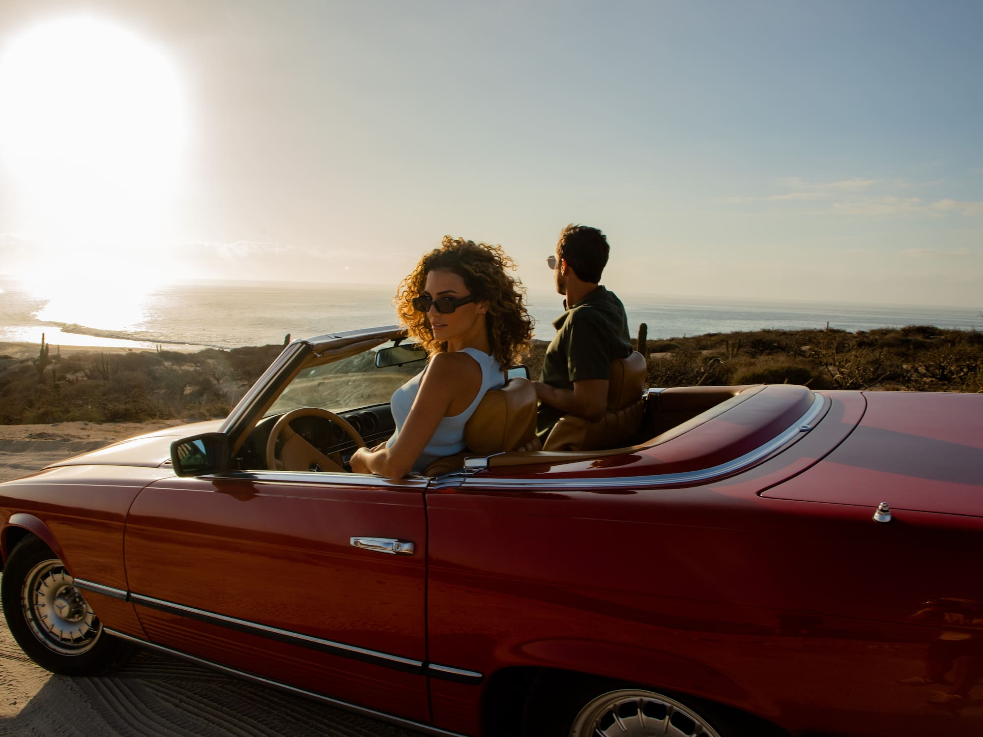 a man and woman in a convertible car