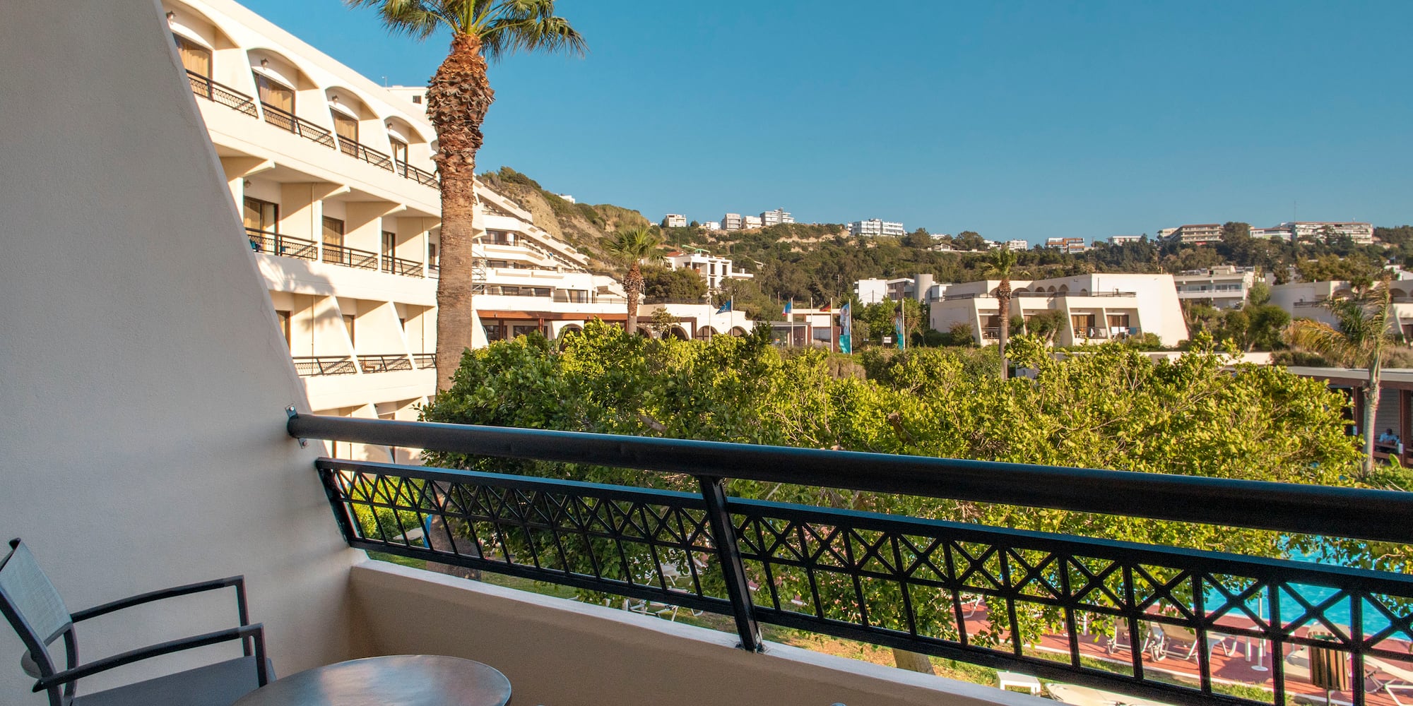 a balcony with a table and chairs and trees