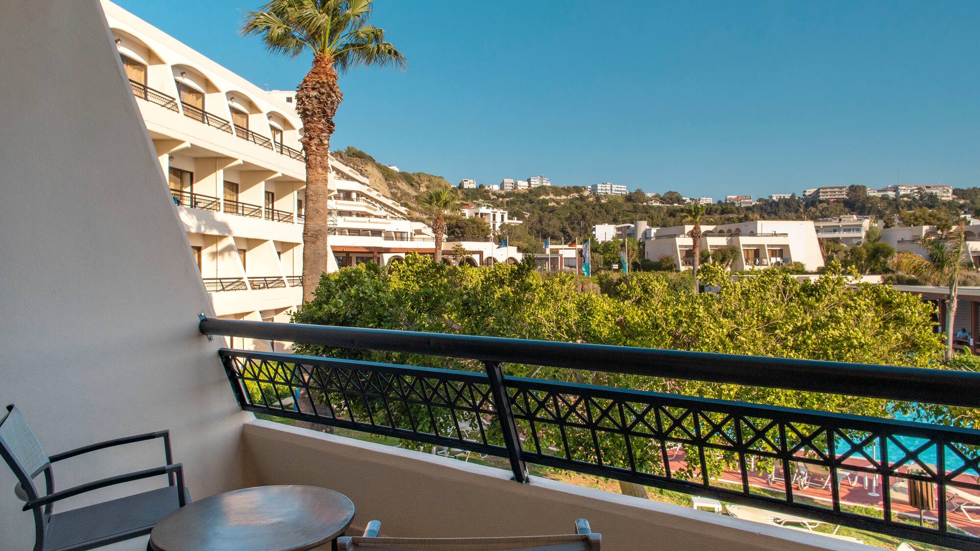 a balcony with a table and chairs and trees