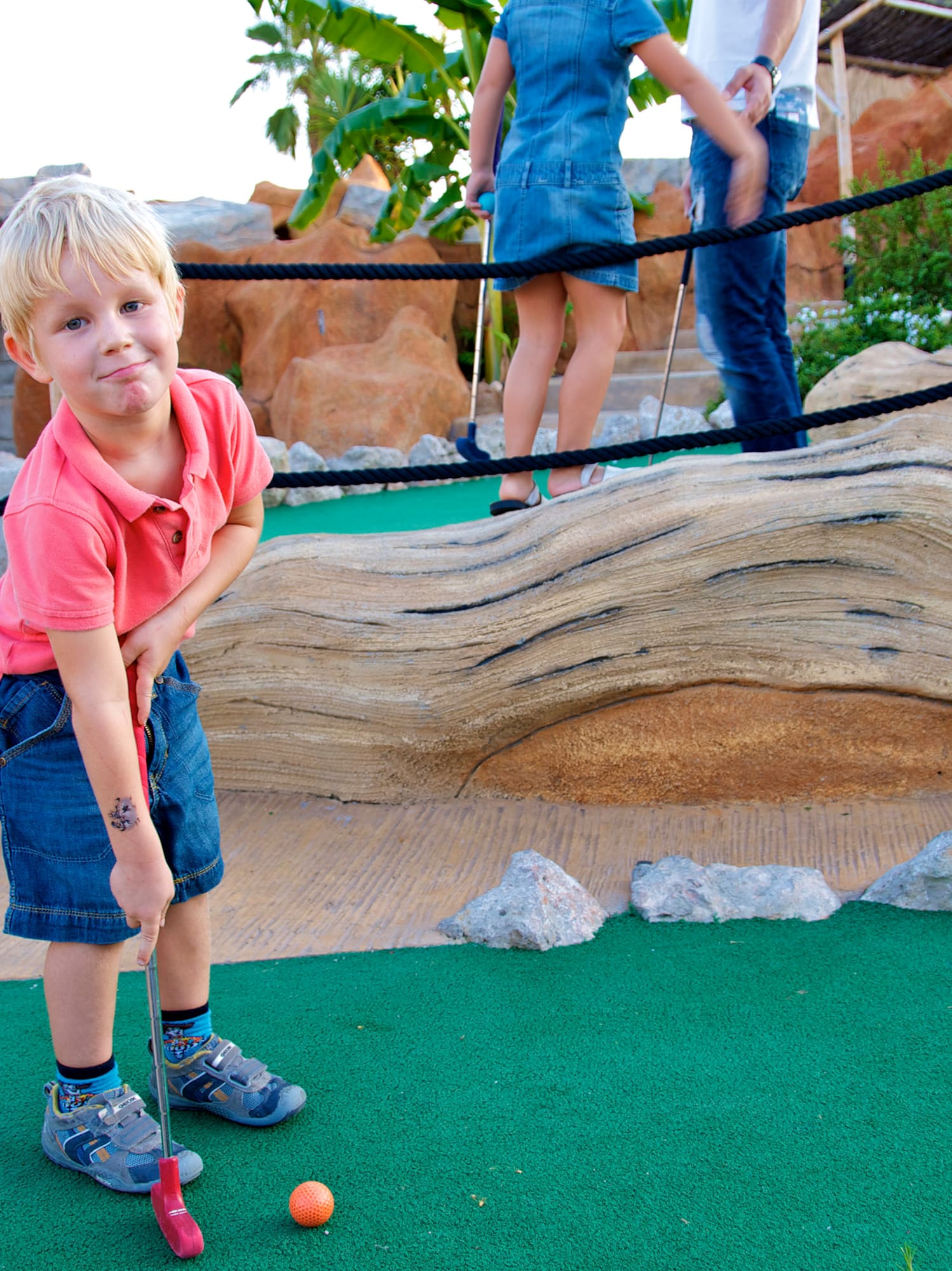 a boy playing golf with a golf ball