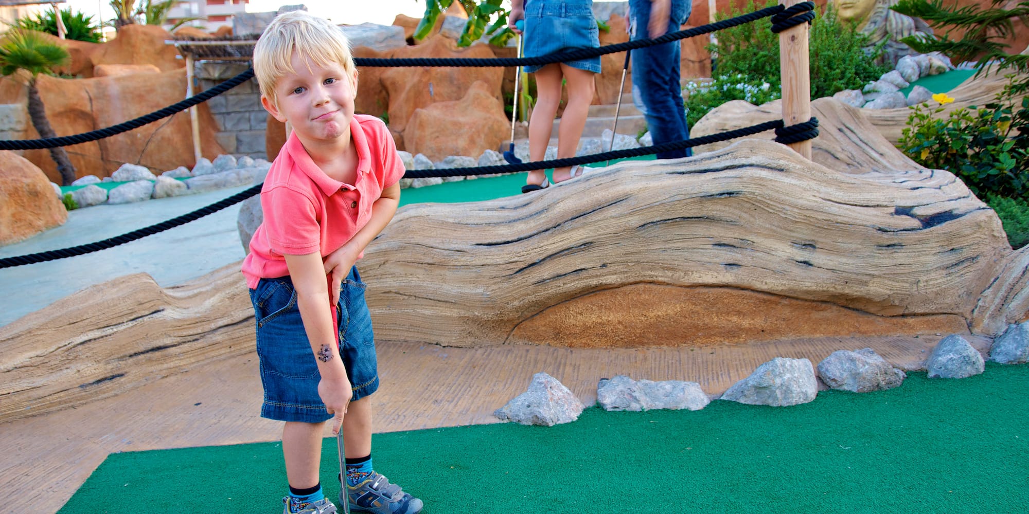 a boy playing golf with a golf ball