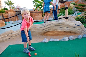 a boy playing golf with a golf ball