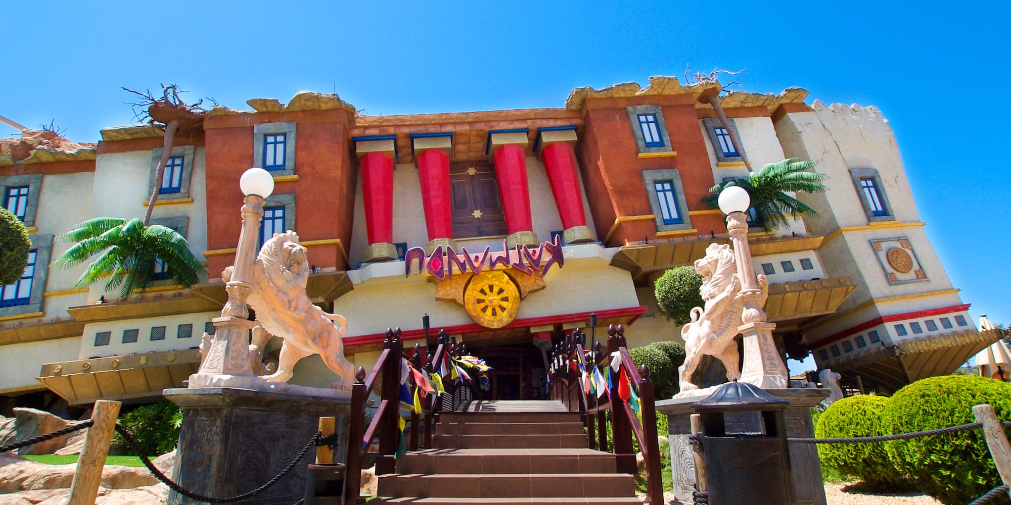 a building with statues and a yellow wheel