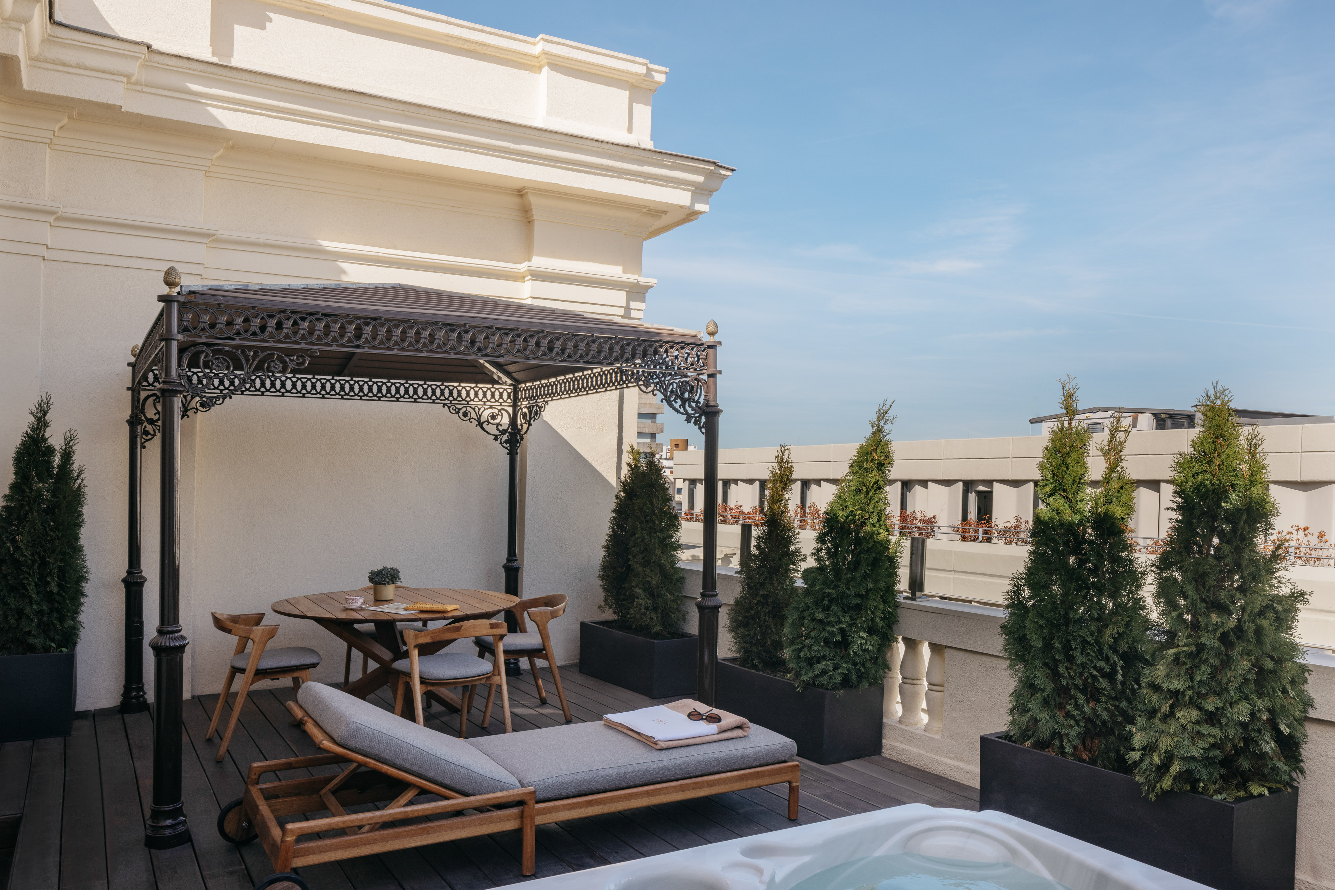 Luxury rooftop terrace with hot tub, outdoor lounge, dining set, and gazebo.