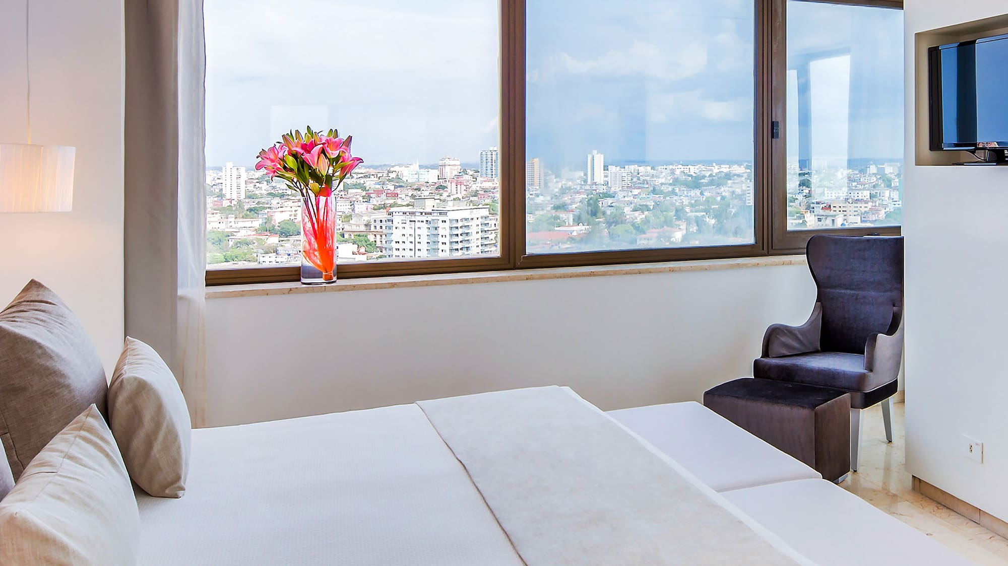 a bedroom with a large window and a large bed