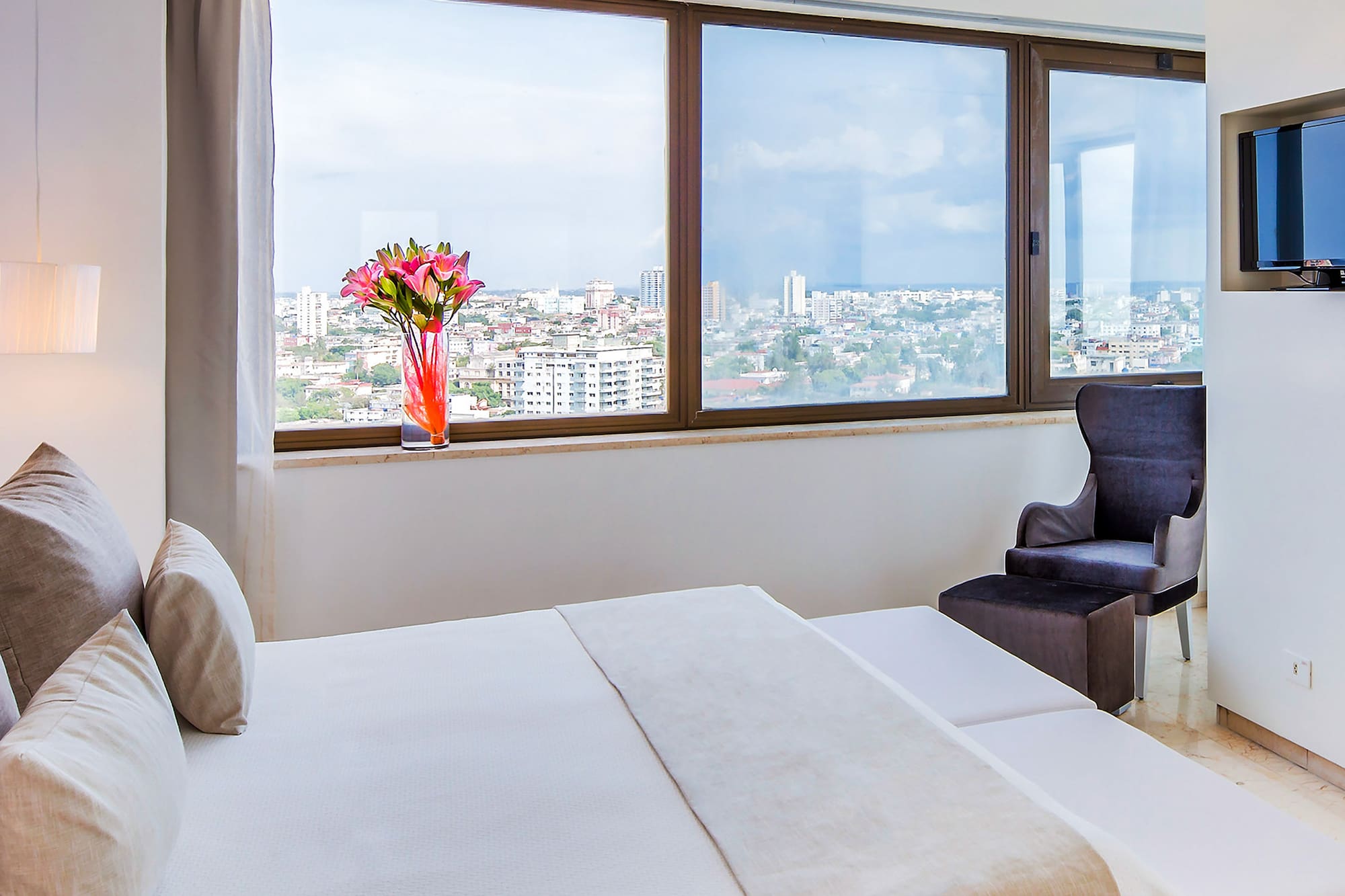 a bedroom with a large window and a large bed