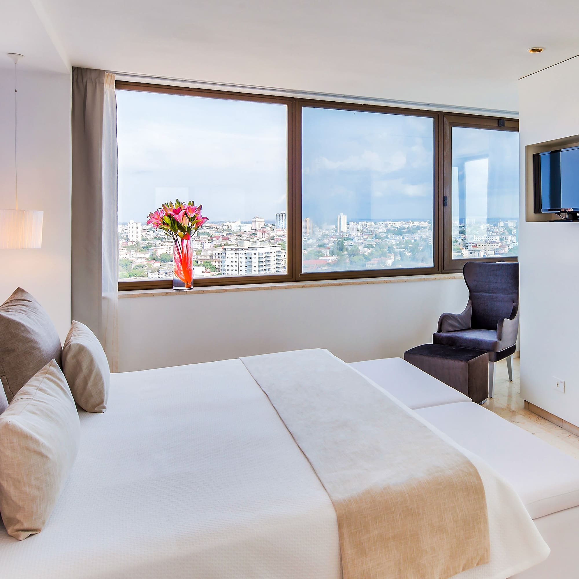 a bedroom with a large window and a large bed