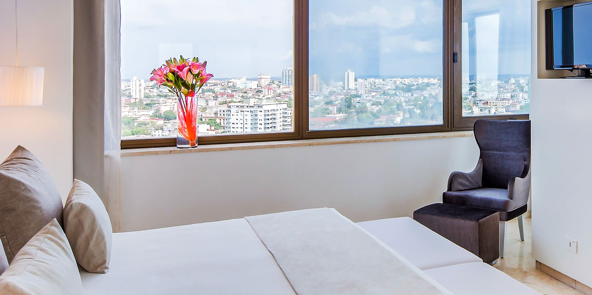 a bedroom with a large window and a large bed