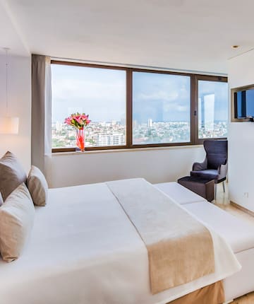 a bedroom with a large window and a large bed