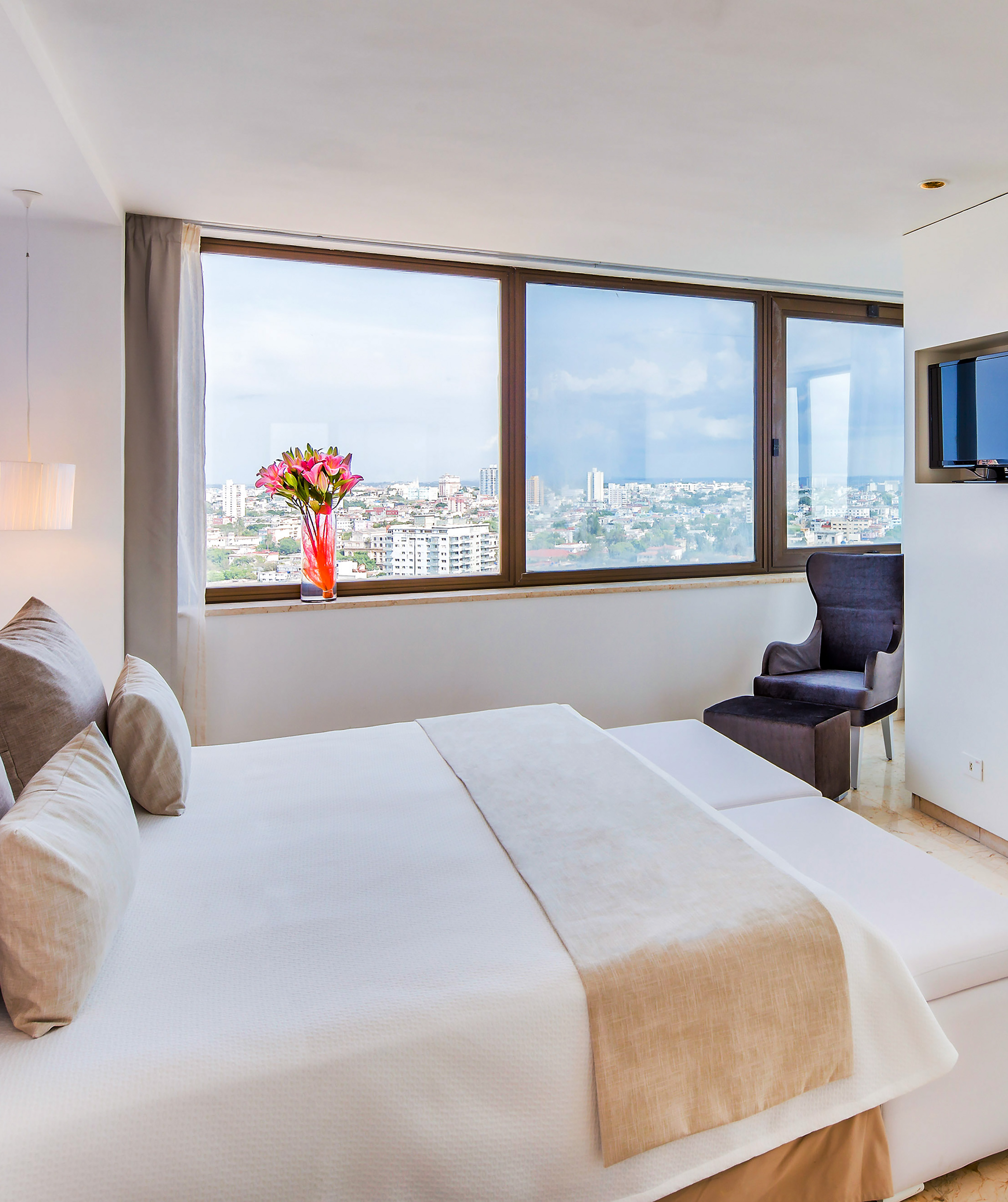 a bedroom with a large window and a large bed