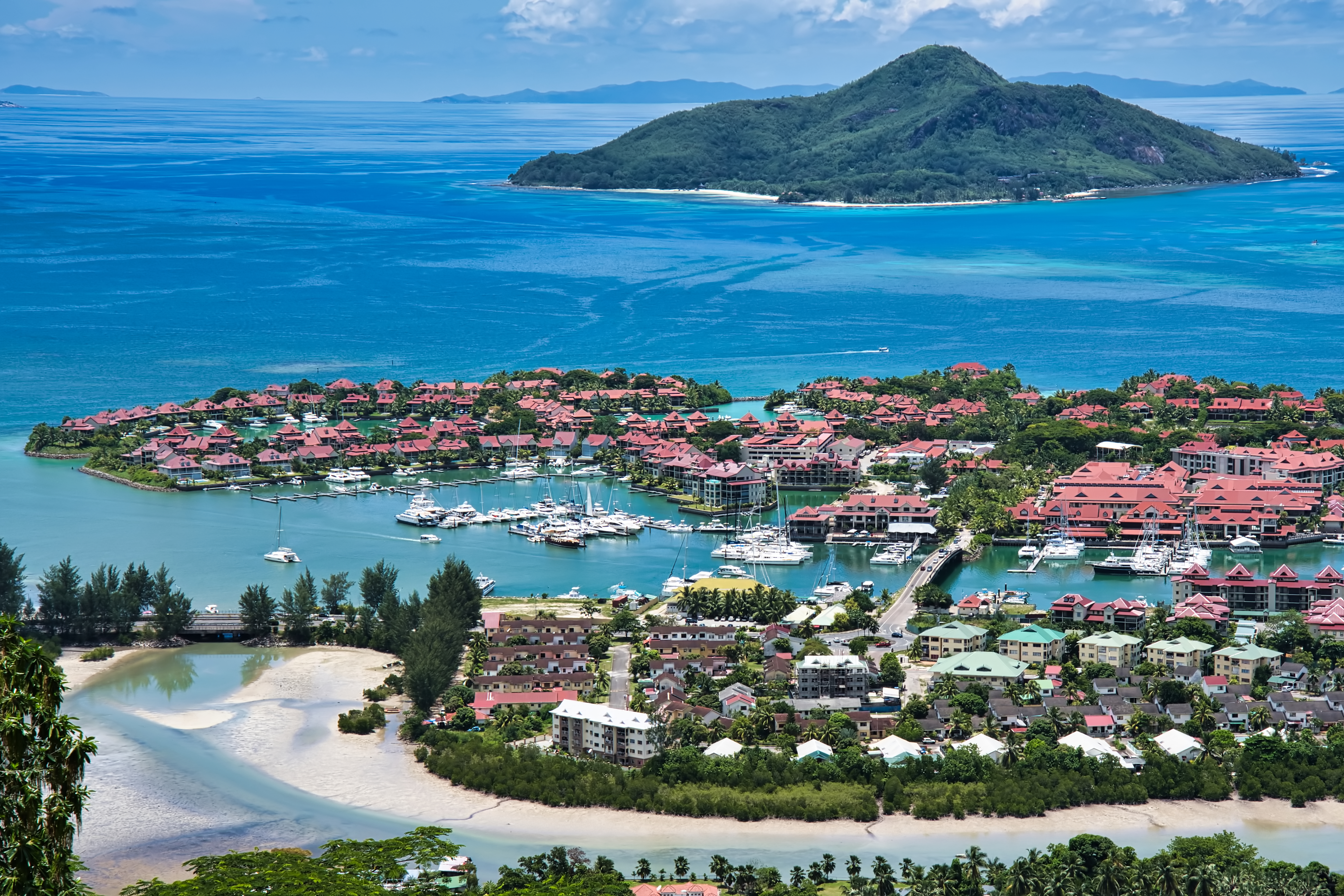Eden Island, Seychelles: vista aérea de marina, casas rojas, yates y océano azul.