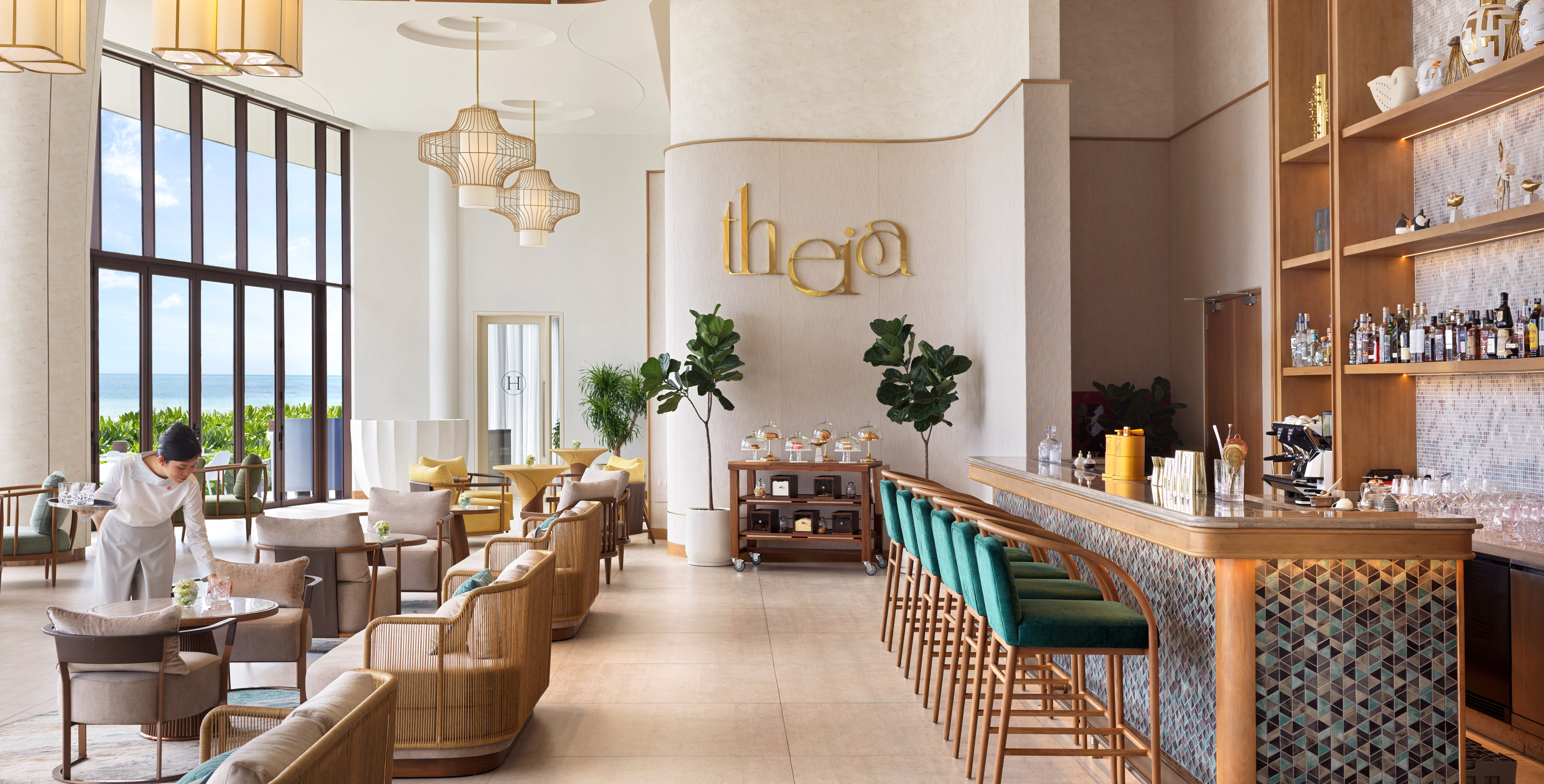 Luxury resort lounge "Theia" with ocean views, bar area, and modern seating.