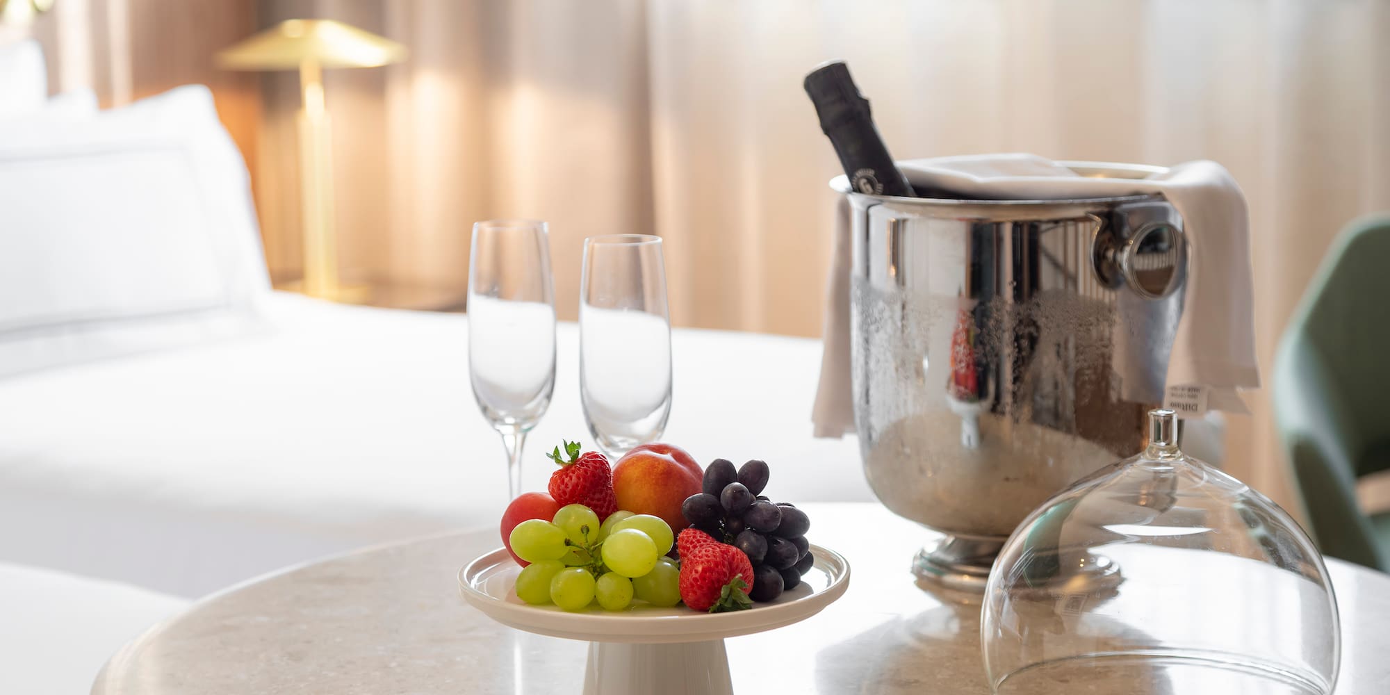 a plate of fruit and wine glasses on a table