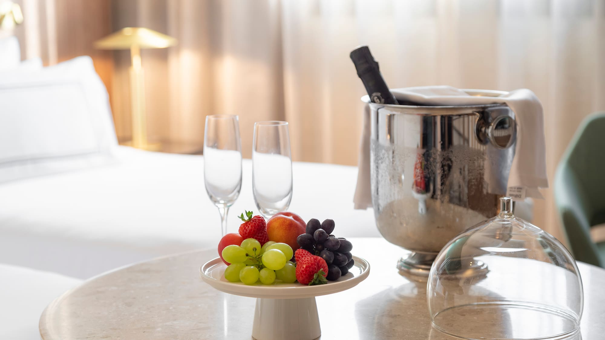 a plate of fruit and wine glasses on a table