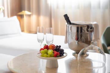 a plate of fruit and wine glasses on a table
