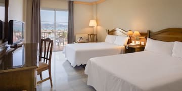 a room with two beds and a table and chairs