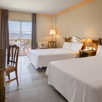 a room with two beds and a table and chairs