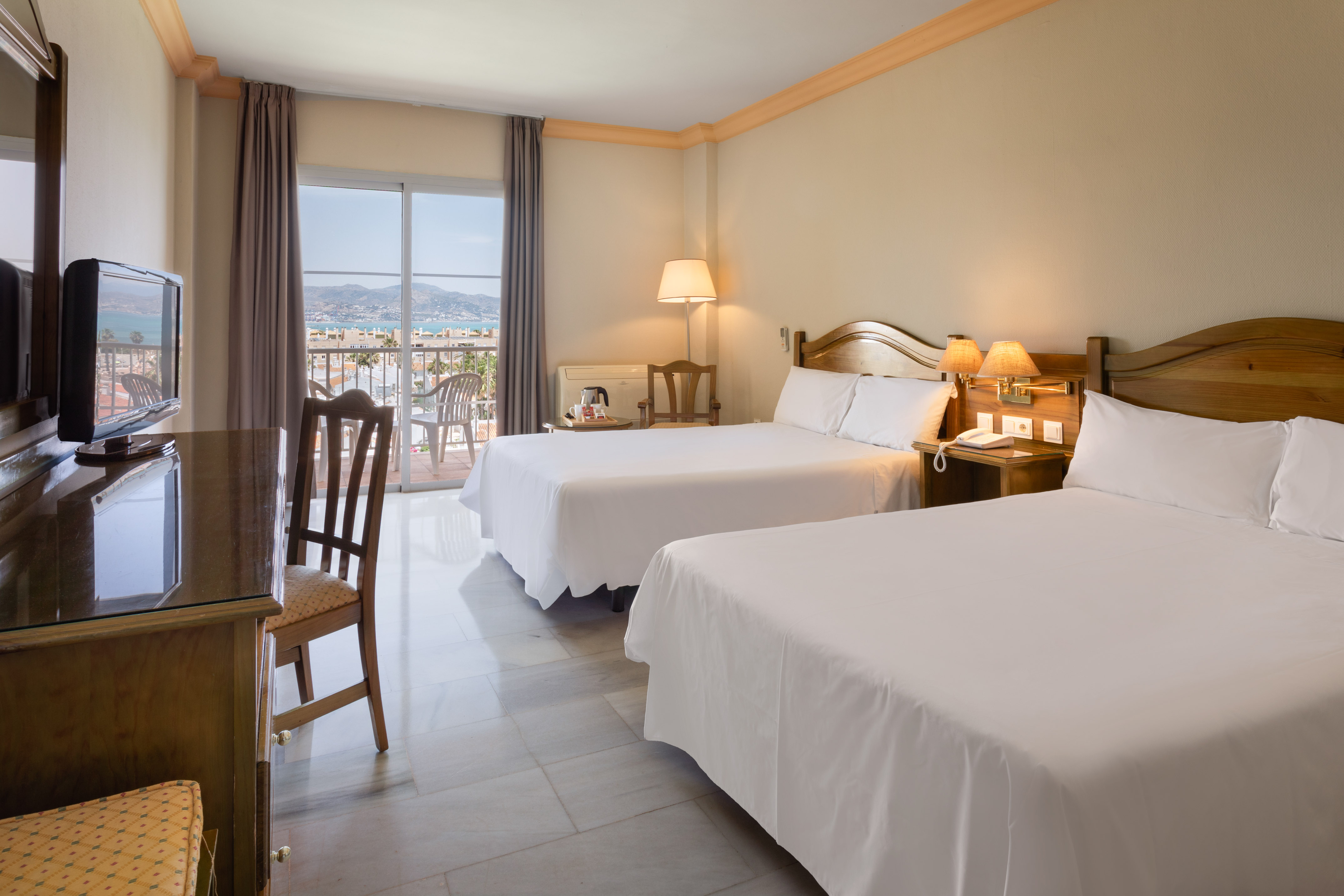 a room with two beds and a table and chairs