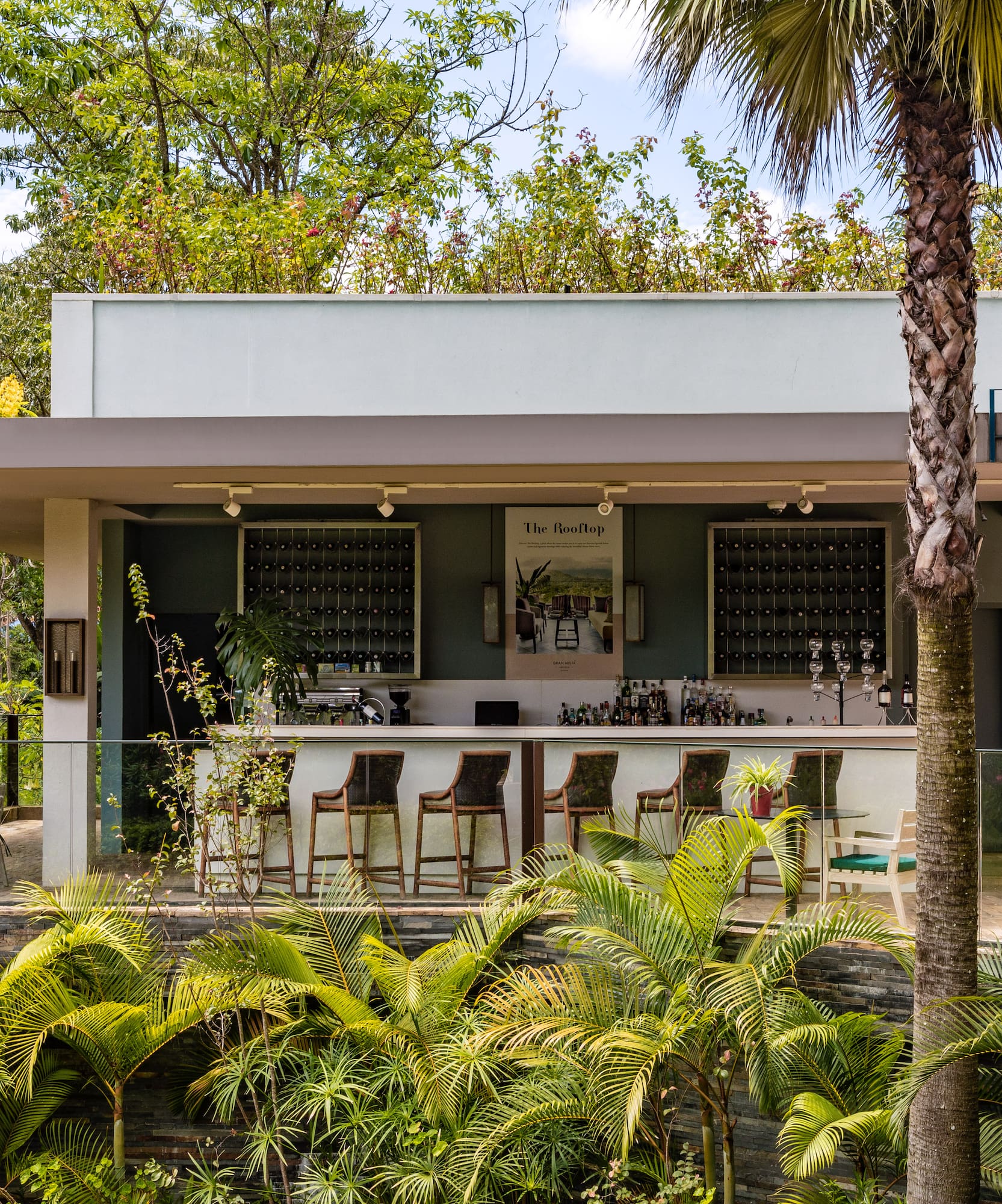 a building with a bar and chairs and trees