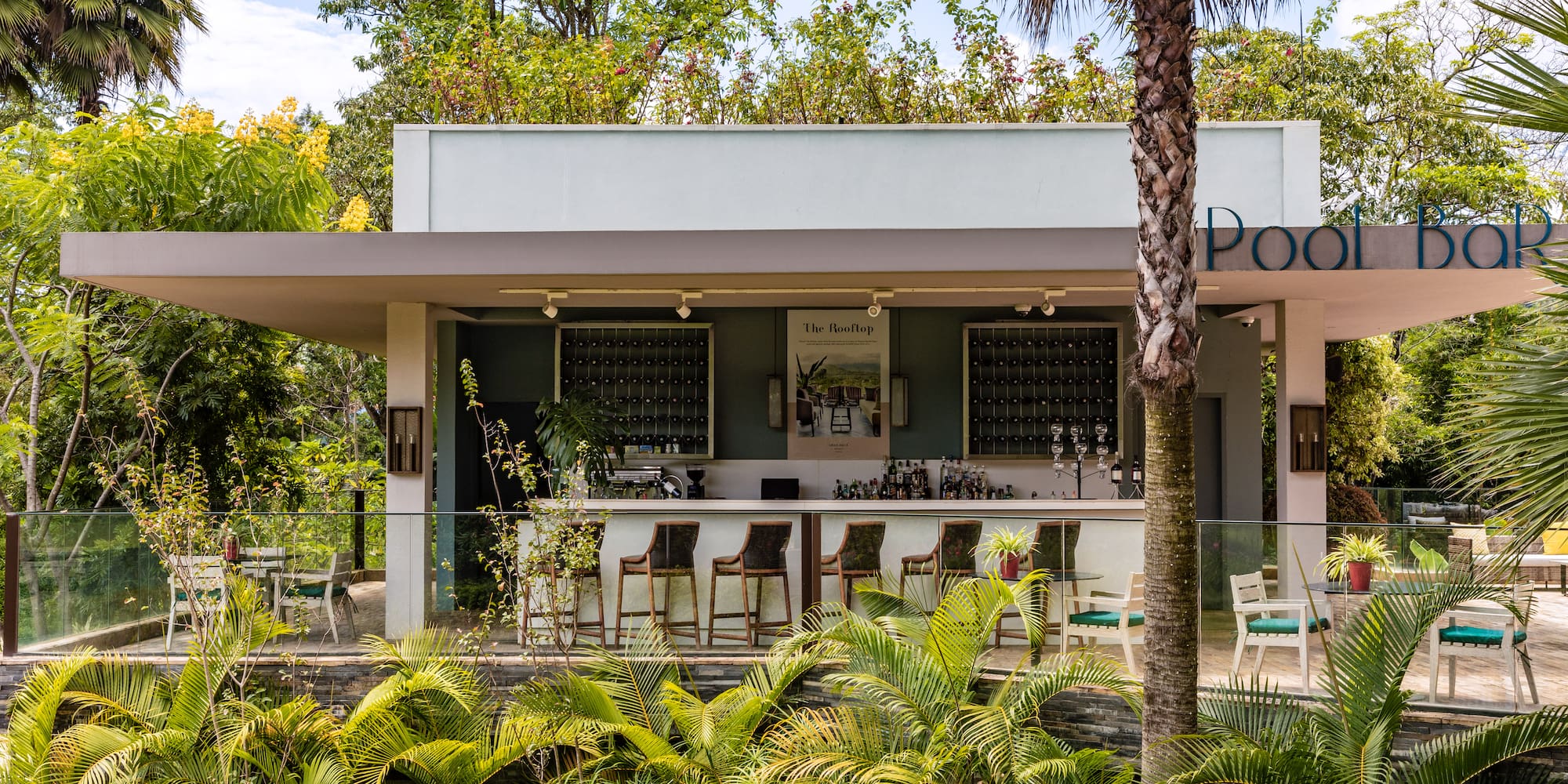 a building with a bar and chairs and trees