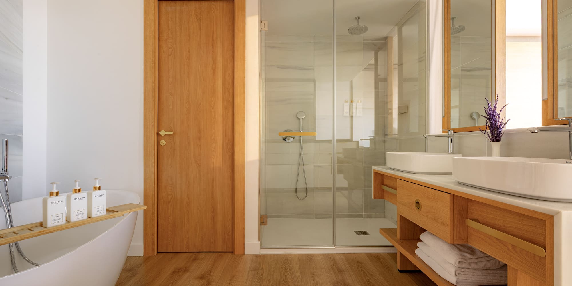 Elegant bathroom with freestanding tub, glass shower, and wooden vanity.