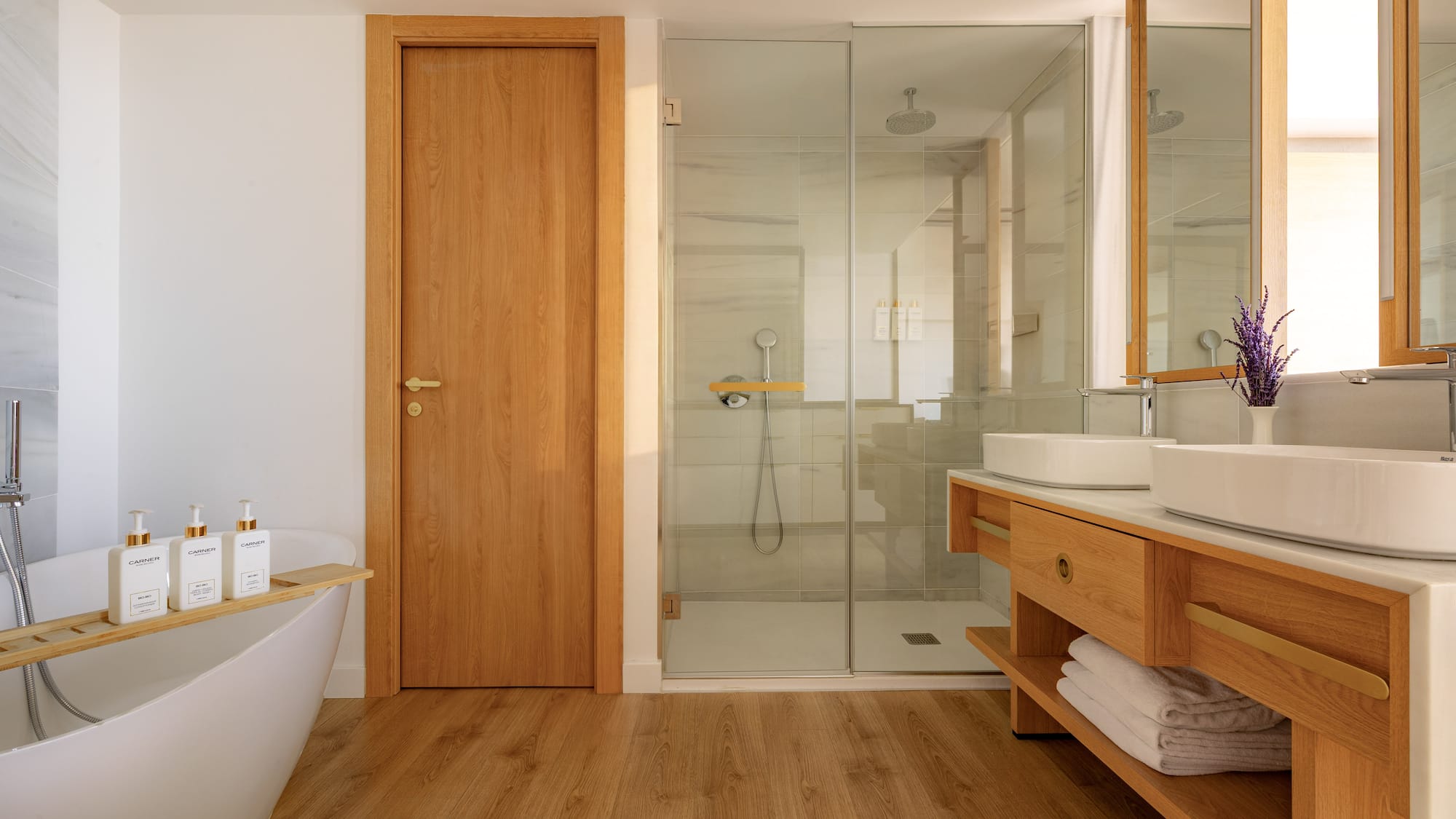 Elegant bathroom with freestanding tub, glass shower, and wooden vanity.