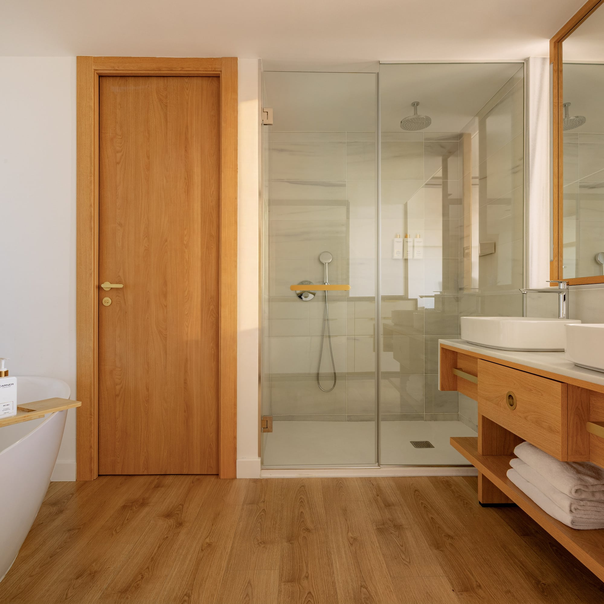 Elegant bathroom with freestanding tub, glass shower, and wooden vanity.