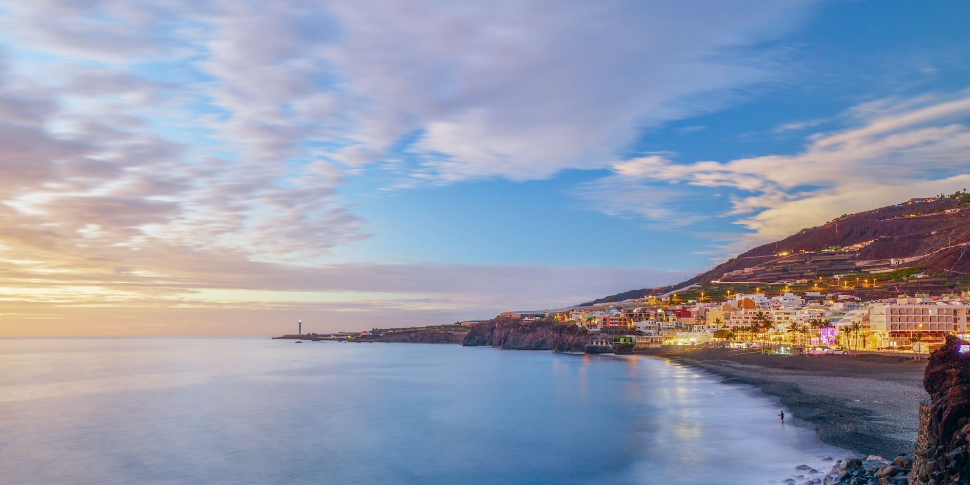 a beach with buildings and a body of water