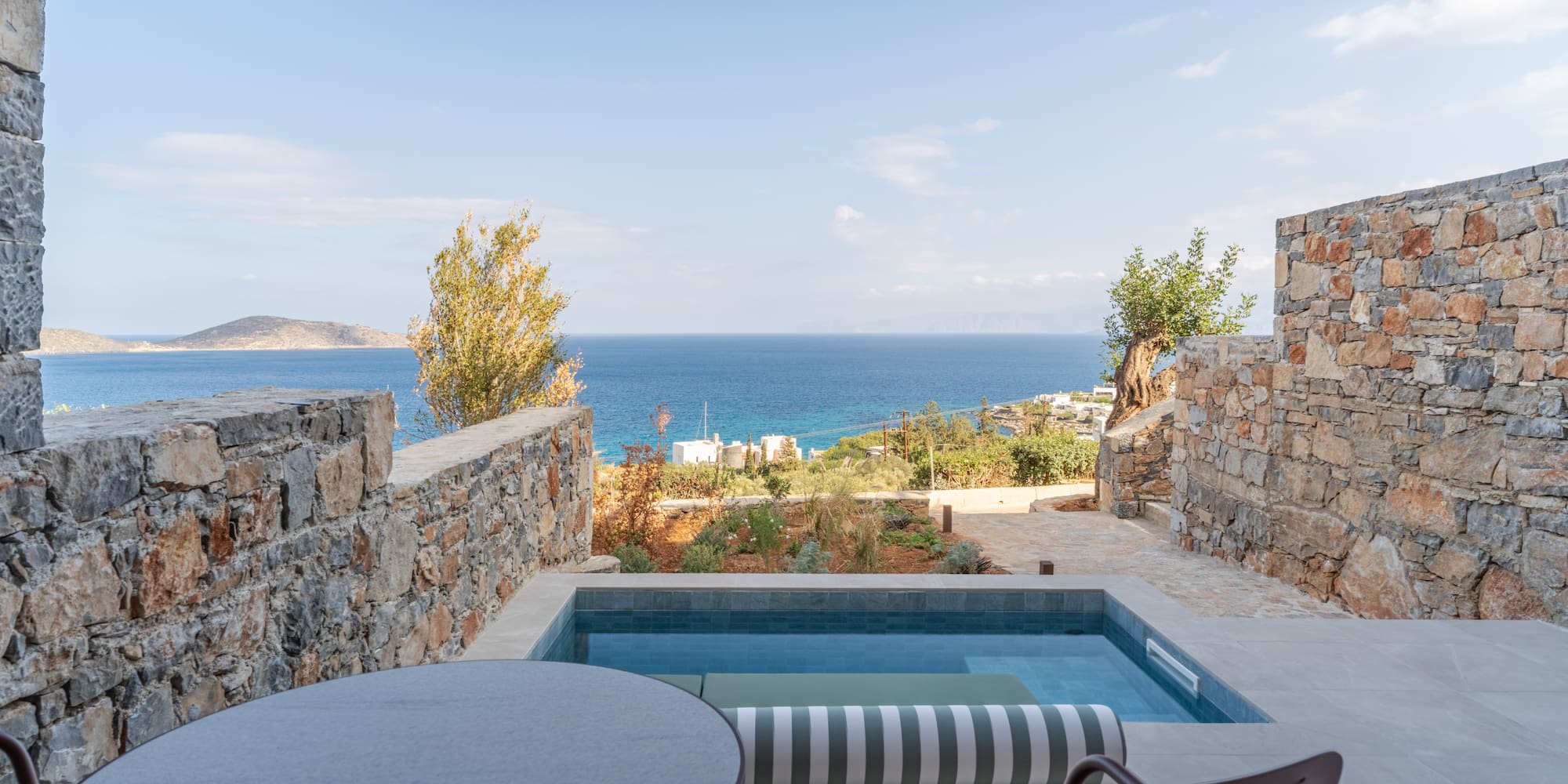 a pool with a table and chairs overlooking a body of water