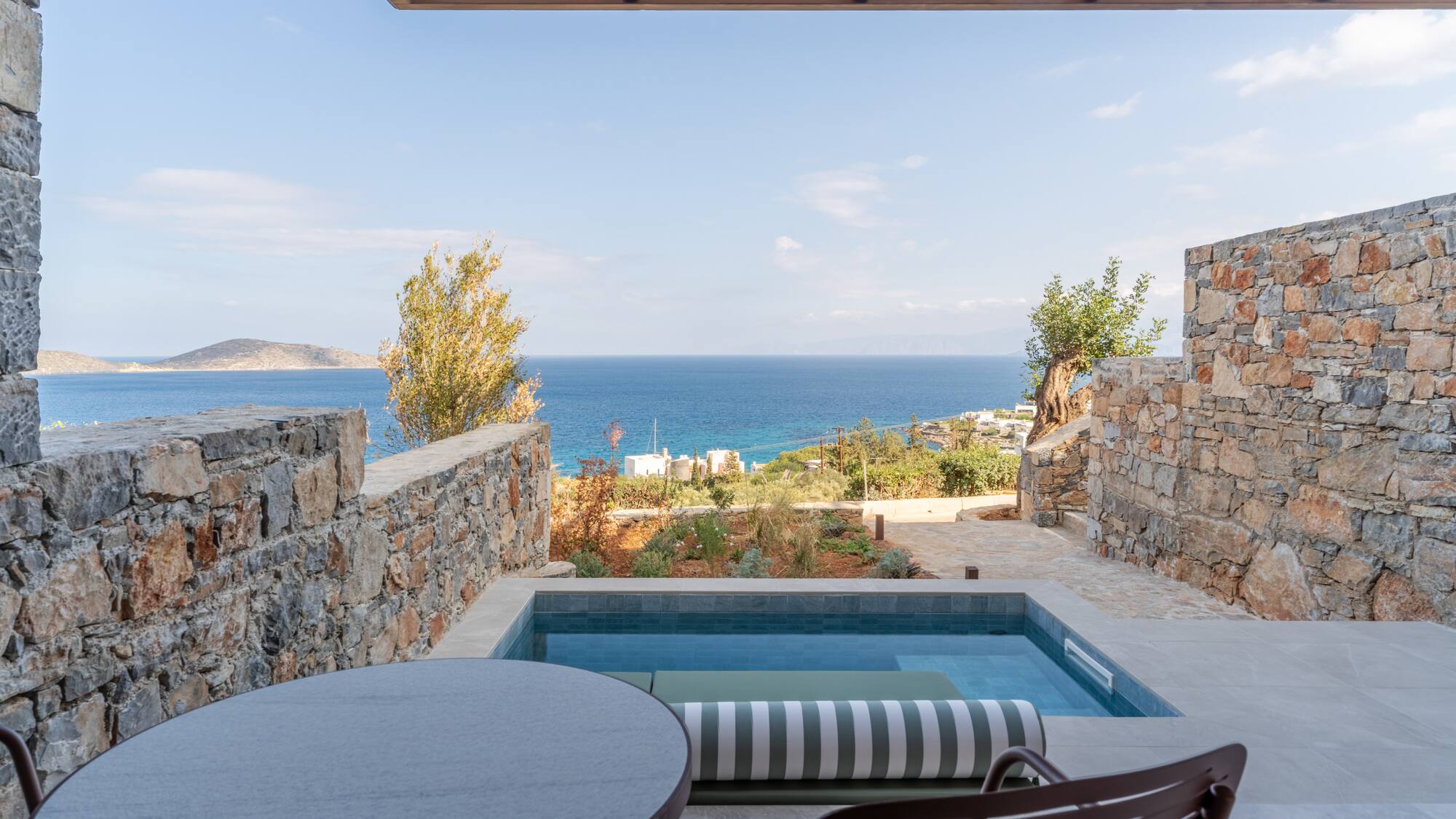 a pool with a table and chairs overlooking a body of water