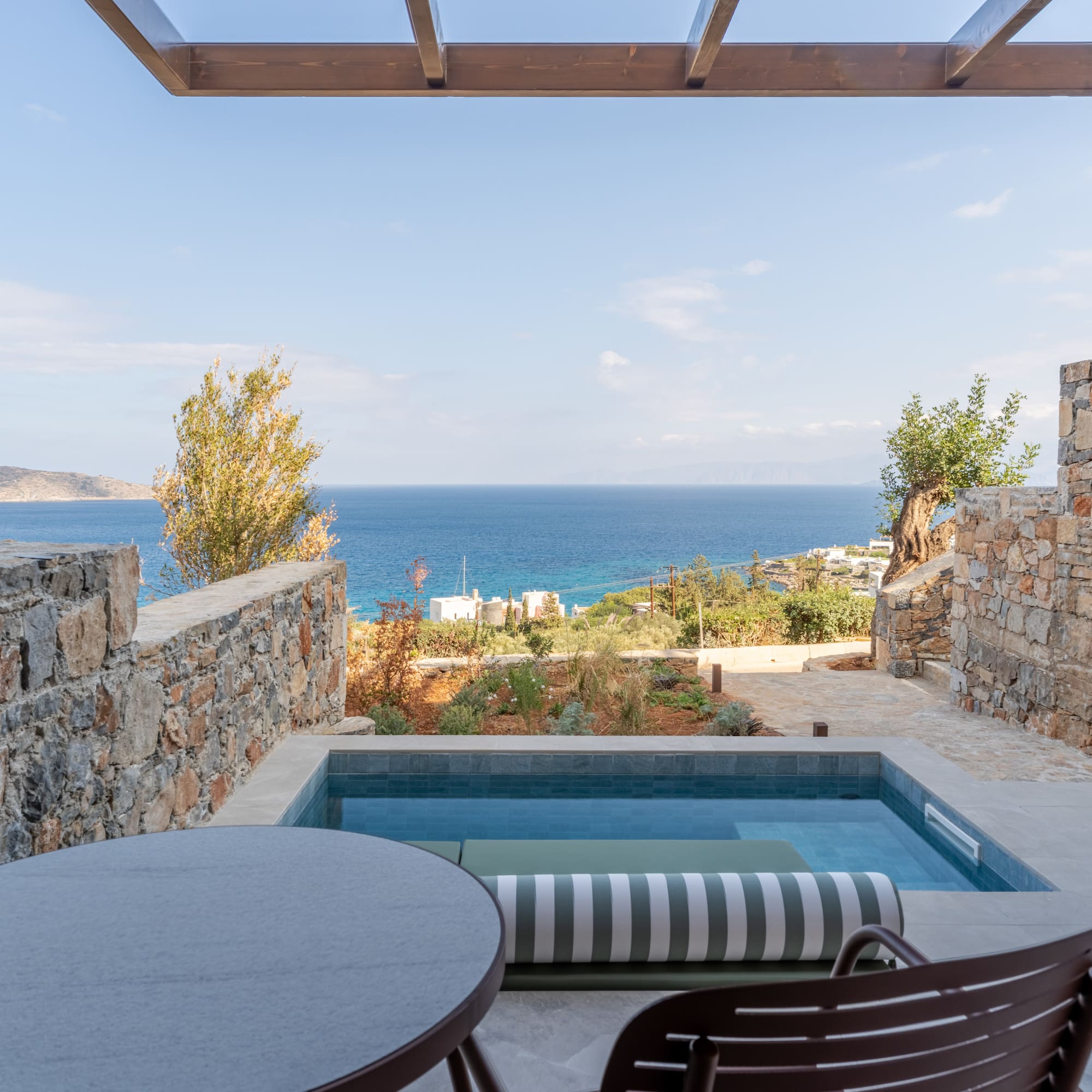 a pool with a table and chairs overlooking a body of water