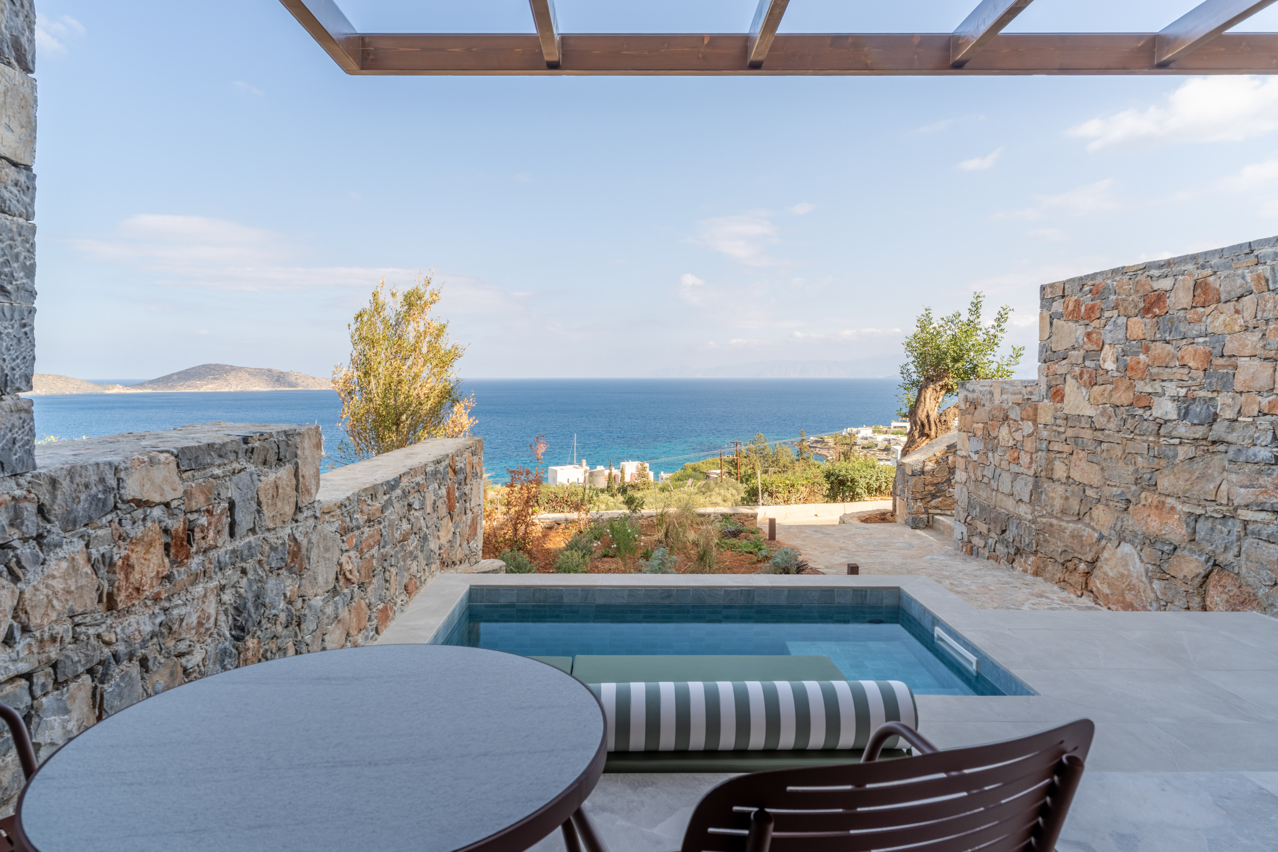 Private plunge pool on a stone terrace with panoramic Mediterranean sea view.