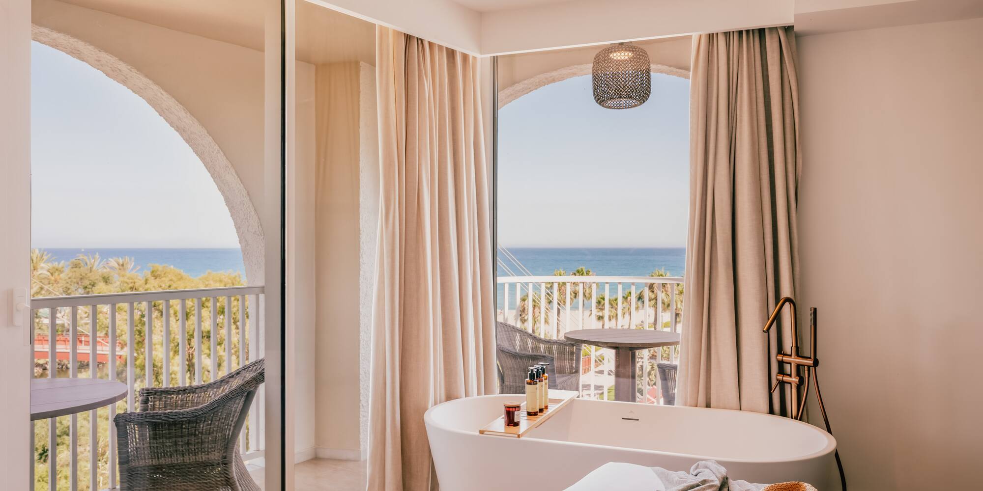 a room with a bathtub and a window with a view of the ocean