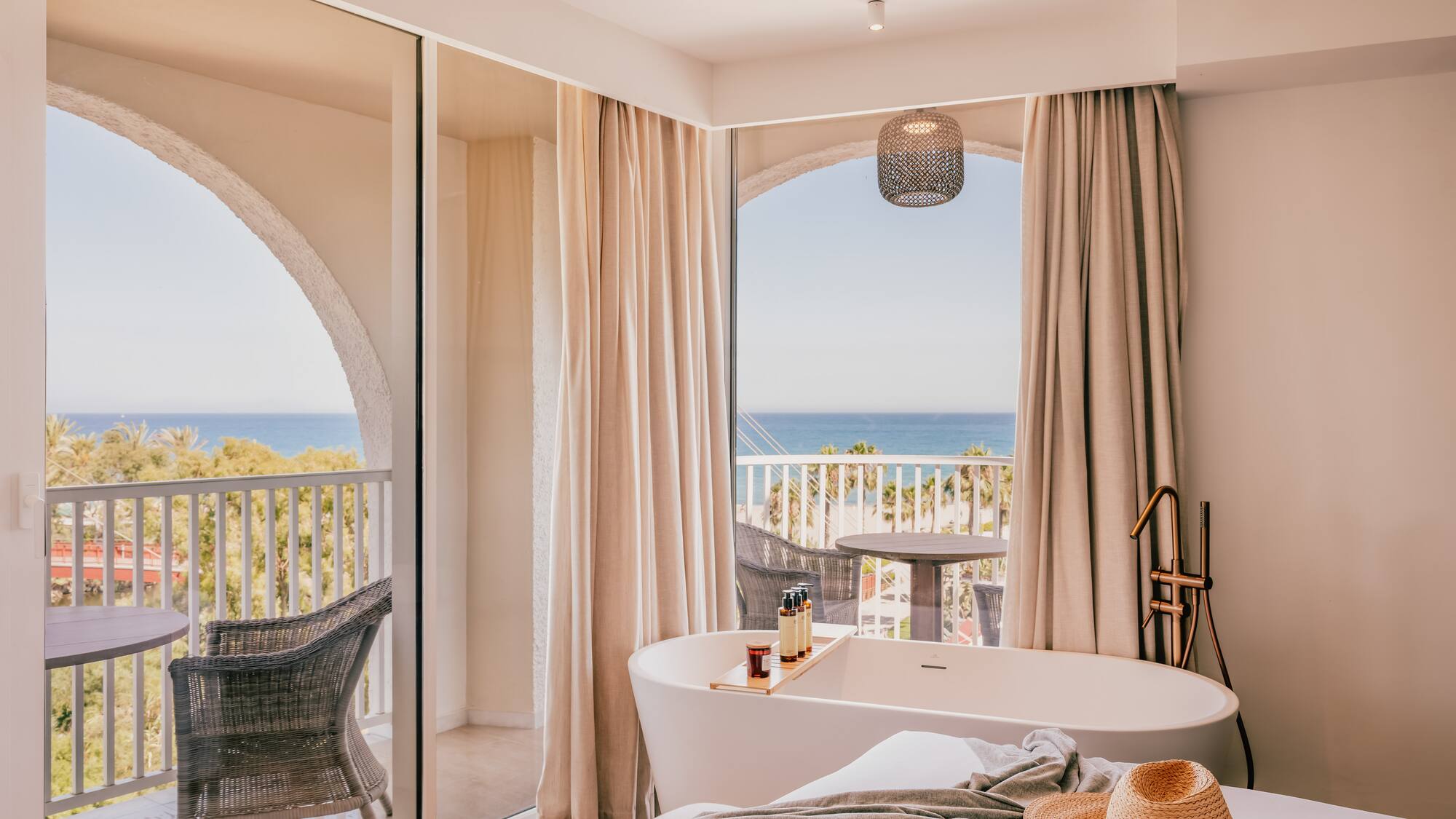 a room with a bathtub and a window with a view of the ocean