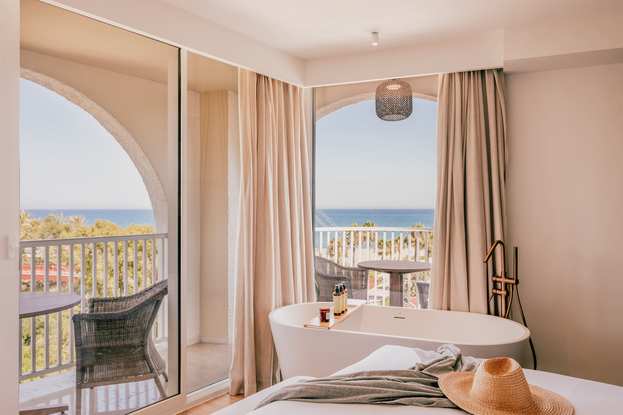 a room with a bathtub and a window with a view of the ocean