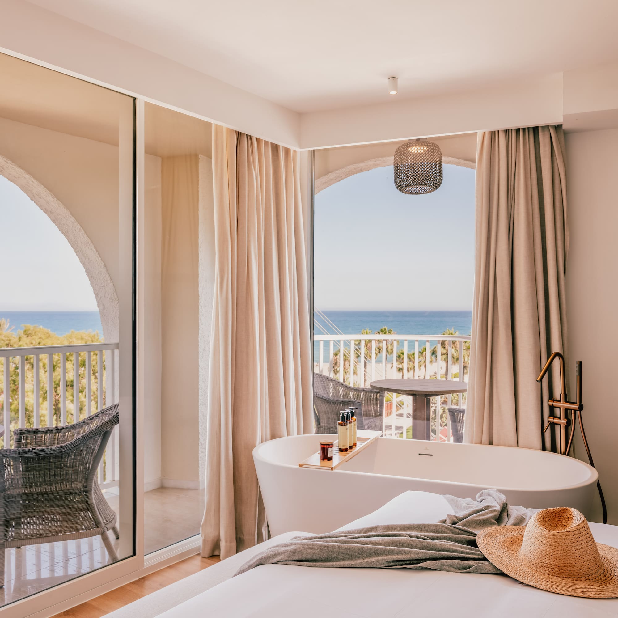 a room with a bathtub and a window with a view of the ocean