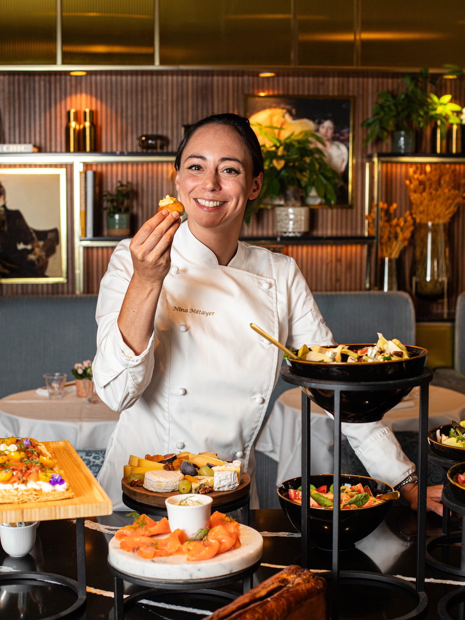 a woman in a chef's uniform holding food