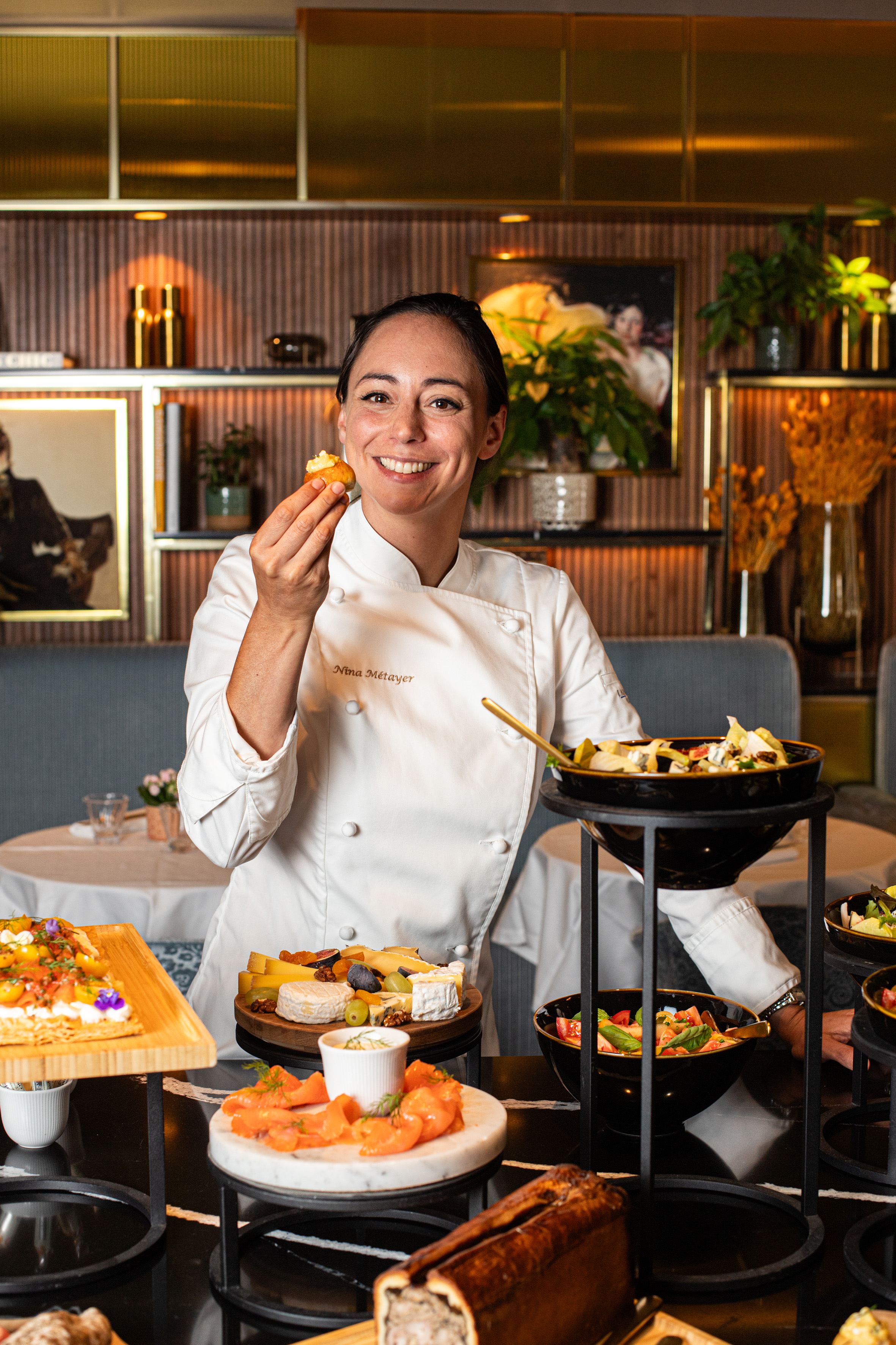 a woman in a chef's uniform holding food