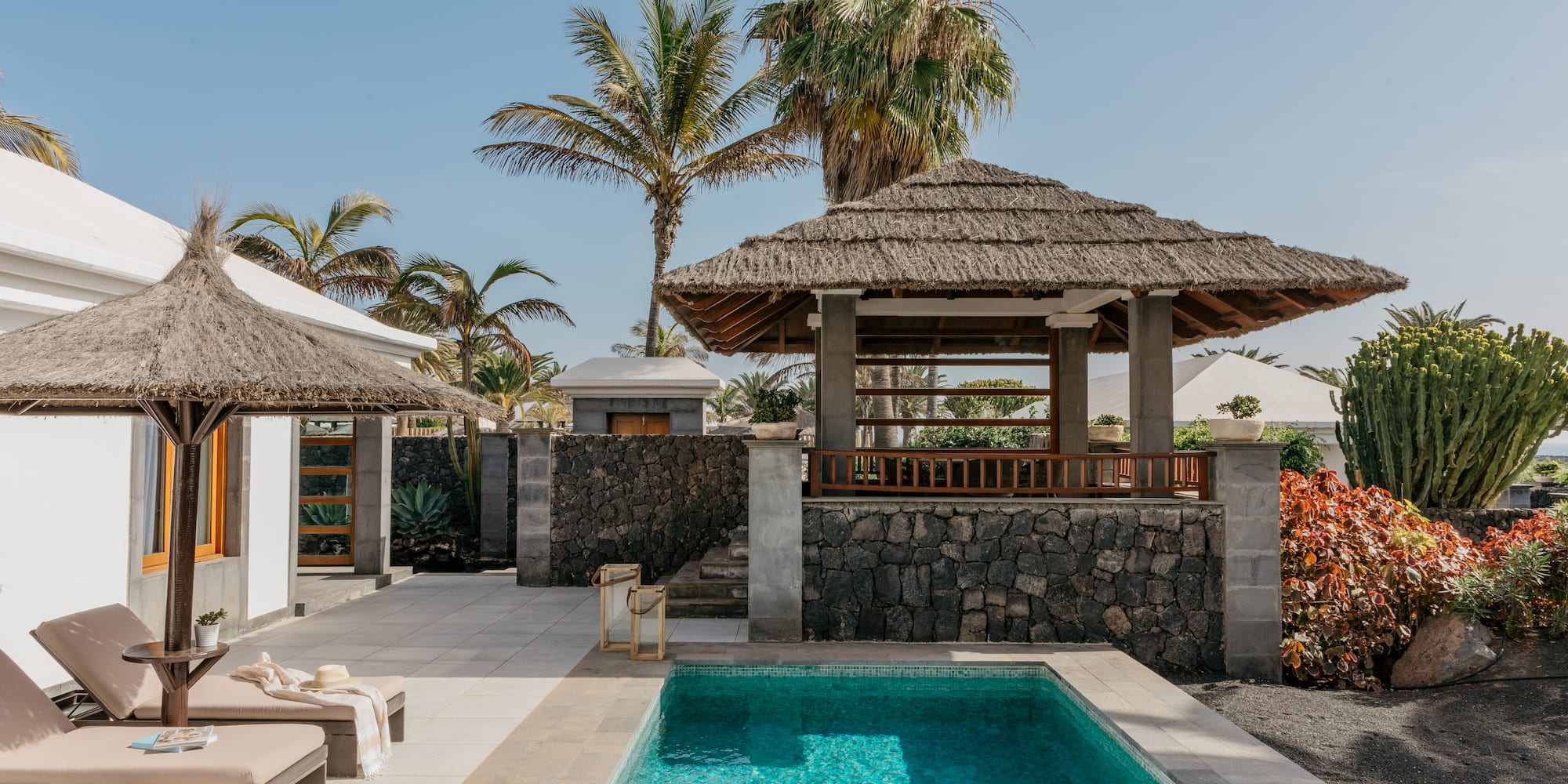 a pool with a gazebo and palm trees