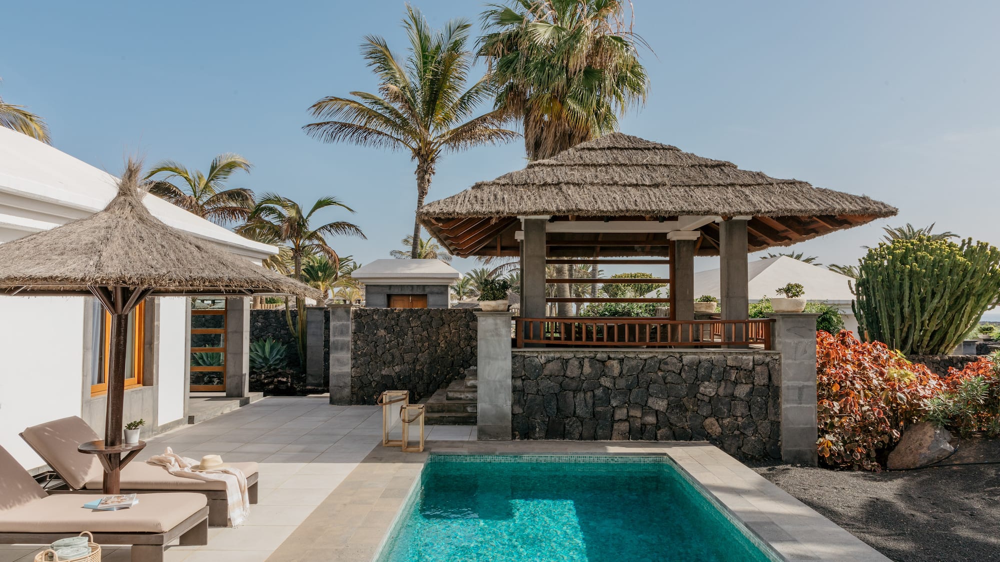 a pool with a gazebo and palm trees