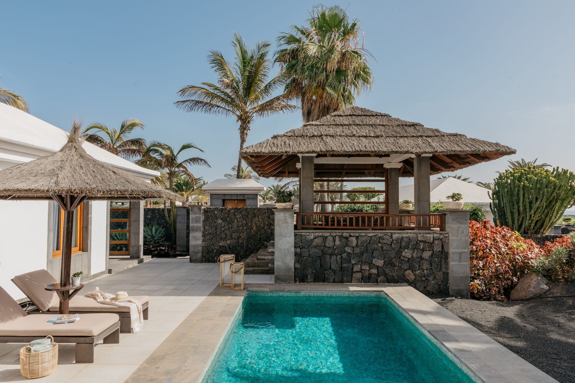 a pool with a gazebo and palm trees