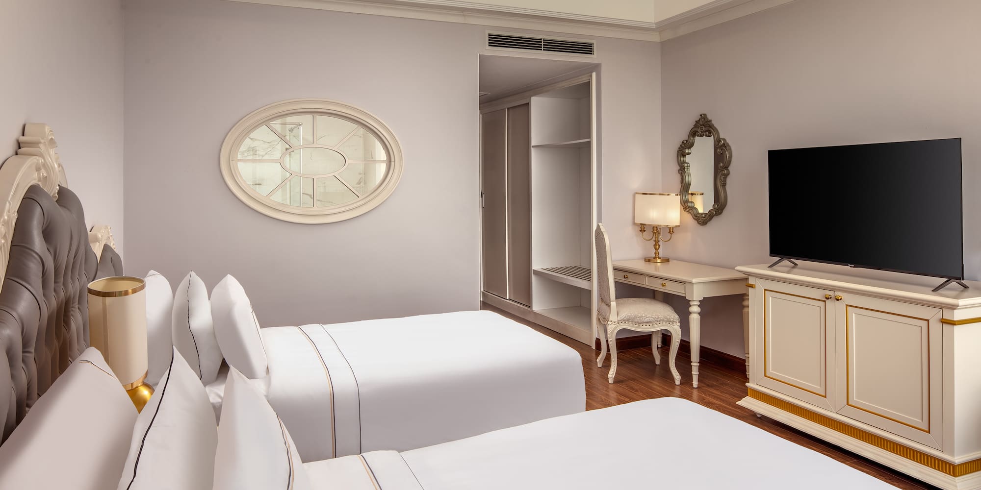 a room with white beds and a desk