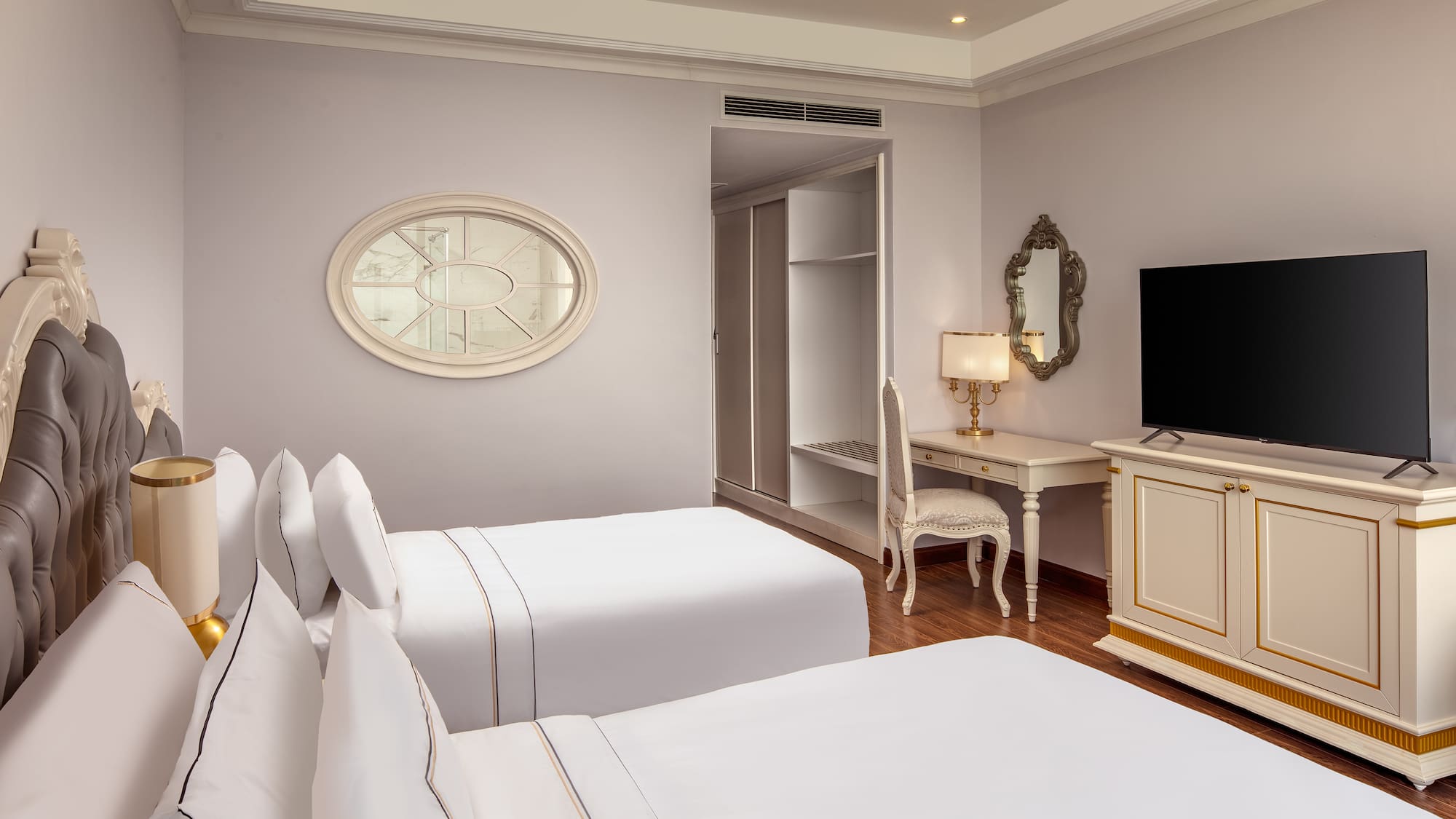 a room with white beds and a desk