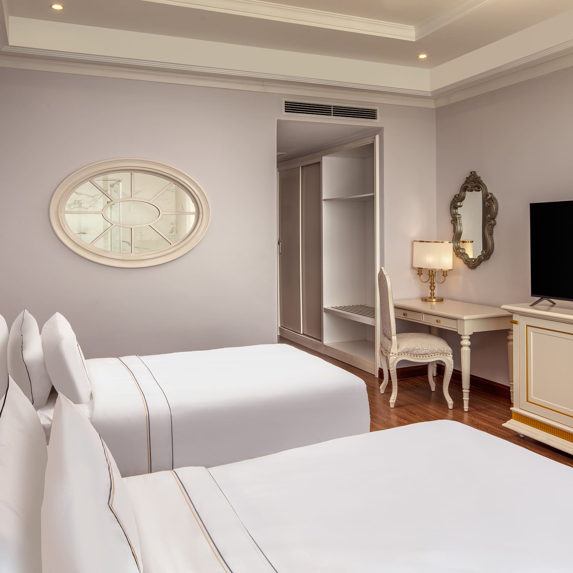 a room with white beds and a desk