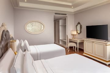 a room with white beds and a desk