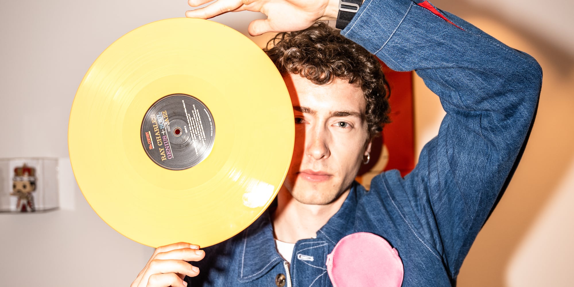 a man holding a yellow record