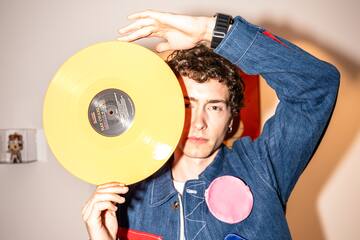 a man holding a yellow record