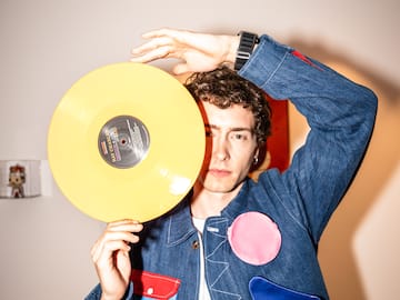 a man holding a yellow record